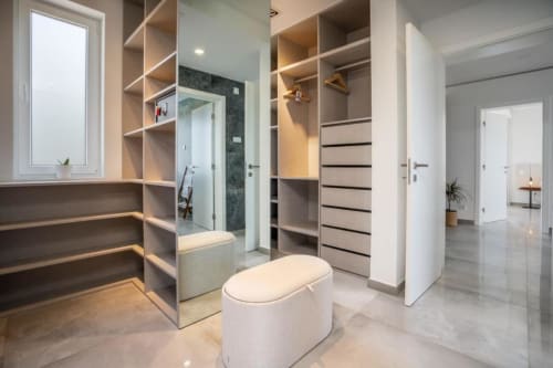Closet de luxo moderno com prateleiras embutidas, gavetas de madeira, banheiro privativo e chuveiro na villa Casa Da Colina