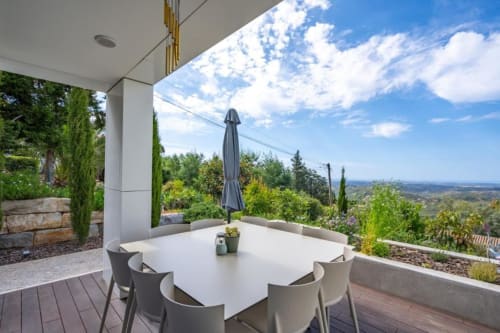 Terraço de jantar ao ar livre na villa Casa Da Colina com vista para as montanhas, mesa para seis, guarda-sol fechado e exuberante vegetação portuguesa
