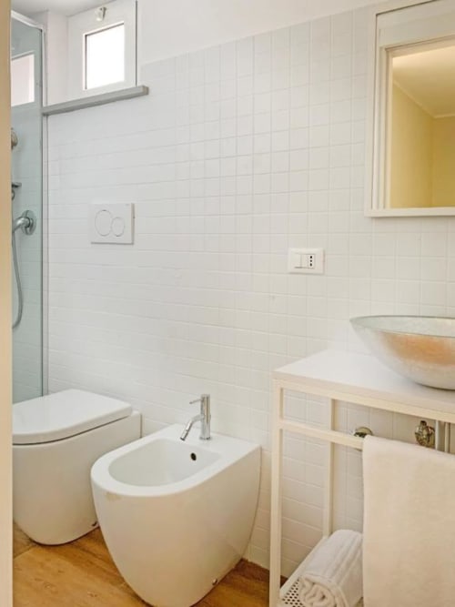 Bagno moderno con piastrelle bianche, bidet, water e lavabo a vessel nella Suite 05 di Residence Balconi del Conero, Marcelli