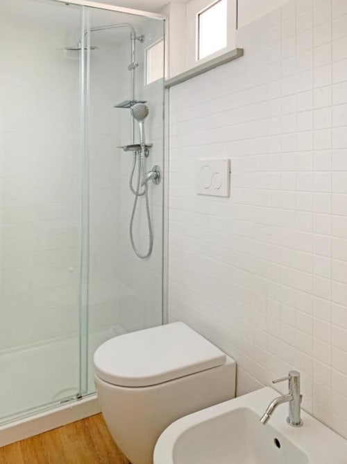Bagno moderno in Residence Balconi del Conero con doccia walk-in, WC, bidet e piastrelle bianche
