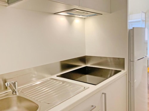 Cucina moderna con piano cottura in acciaio inox, fornelli e lavello nella Suite 05 di Residence Balconi del Conero, Marcelli