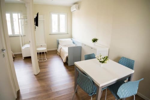 Modern apartment at Residence Balconi del Conero in Marcelli with dining table, bed, and wooden flooring