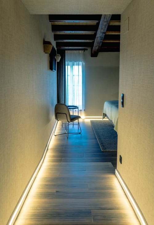 Pasillo moderno de Casa Rural San Andres de Teixido con suelos de madera, vigas vistas, luz natural y mobiliario contemporáneo