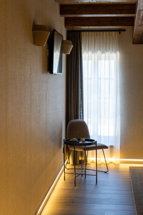 Habitación moderna en Casa Rural San Andres de Teixido con vistas al mar, silla minimalista, vigas de madera y luz natural