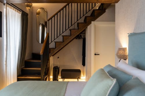 Dormitorio loft moderno con escalera de madera, cabecero azul y vistas al mar en Teixido, A Coruña