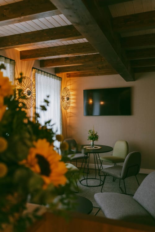Sala de estar moderna en la casa rural San Andres de Teixido con girasoles, arte geométrico en pared, mesa y sillas de comedor