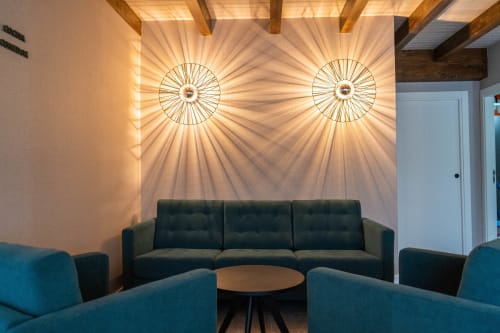 Sala de estar moderna con sillones color turquesa, sofá oscuro, vigas de madera en techo y lámparas colgantes decorativas en Casa Rural San