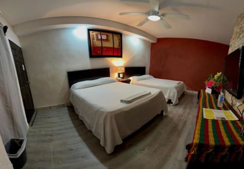 Habitación doble del Hotel Makarios en Tuxtla Gutiérrez con dos camas, techo curvo y mobiliario moderno