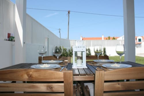Outdoor dining setup at Recantus Comporta with place settings, wine glasses, and ocean view in Comporta, Portugal