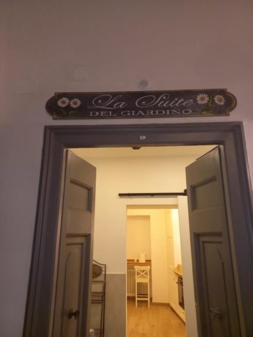 Elegante ingresso della suite La Suite del Giardino a Napoli con segnaletica decorativa