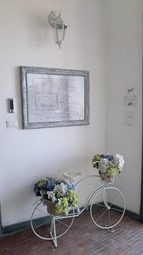 Bicicletta decorativa bianca con fiori blu e bianchi nella hall di La Suite del Giardino, hotel di Napoli