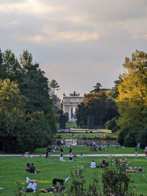 Parc Sempione à Milan avec pelouse, arbres et l'Arco della Pace visible au loin