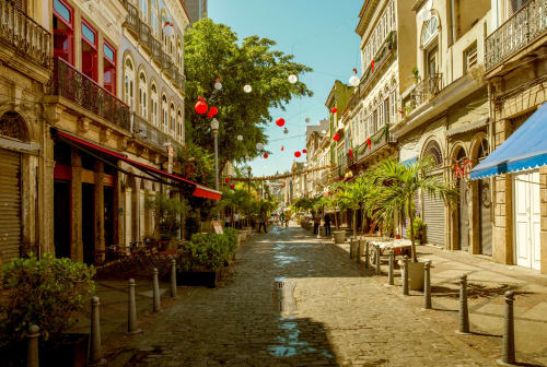Charming cobblestone street in Rio de Janeiro with colonial architecture, red lanterns, and shops near Rio Vibes Hostel