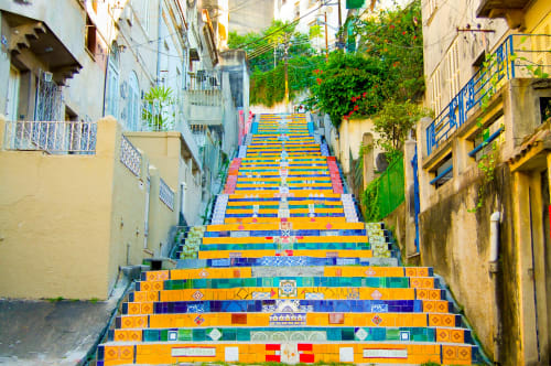 Colorful tiled staircase in Rio de Janeiro street leading through narrow alley with green ivy and colonial buildings