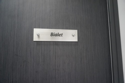 Pancarte Bialet sur porte texturée gris foncé à l'Hôtel Saint Roch à Saint-Ybarct, France