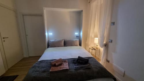 Camera moderna dell'appartamento Maso Kreuzberg a Trento con letto integrato, biancheria bianca e vista sul giardino