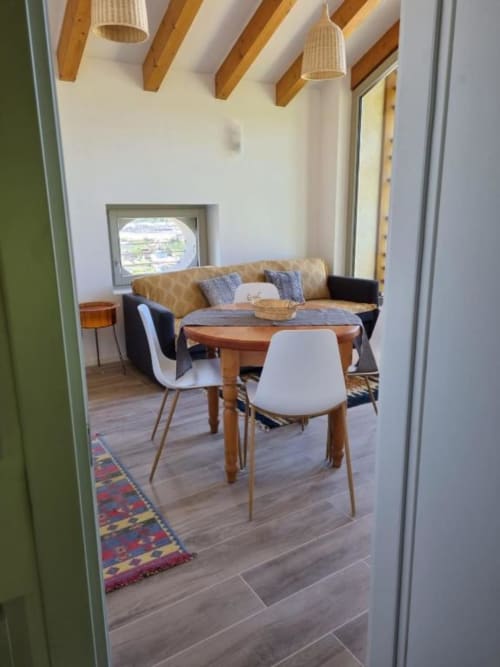 Moderno appartamento a Maso Kreuzberg a Trento con zona pranzo, vista montagna, travi in legno e arredi contemporanei