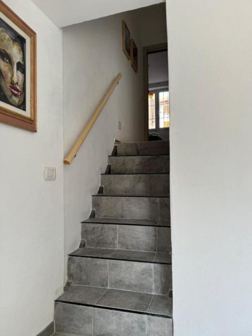 Moderna scala con gradini in piastrelle scure e ringhiera in legno nell'appartamento Sormano presso THE V Collection, hotel con vista montagna