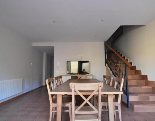 Zona de comedor y estar integrados en la cabaña Nieva con escalera de madera y vistas a la ciudad