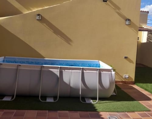 Piscina elevada en el patio de la cabaña Tradición Rural en Nieva con muros de estuco beige y patio de ladrillo