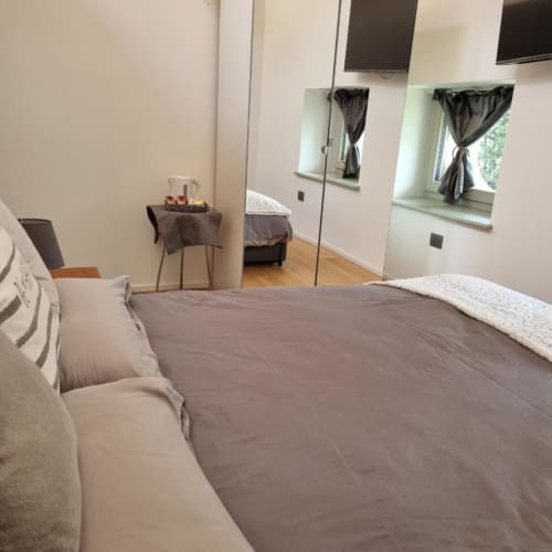 Camera moderna all'Apartment Maso Kreuzberg a Trento con vista giardino, armadio specchiato e pavimento in legno