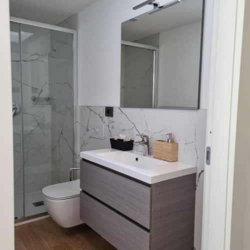 Bagno moderno del Maso Kreuzberg BnB a Trento con doccia in marmo, lavabo a parete, wc e specchio