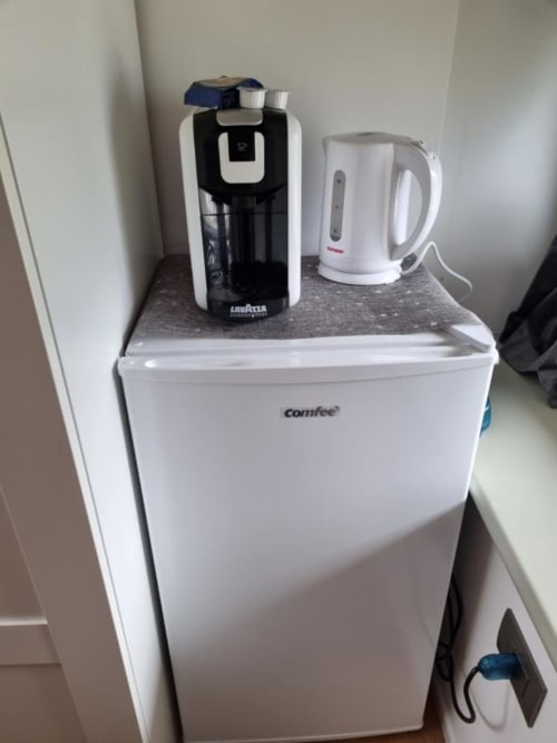 Minibar compatto con caffettiera e bollitore elettrico in camera presso l'appartamento Maso Kreuzberg a Trento