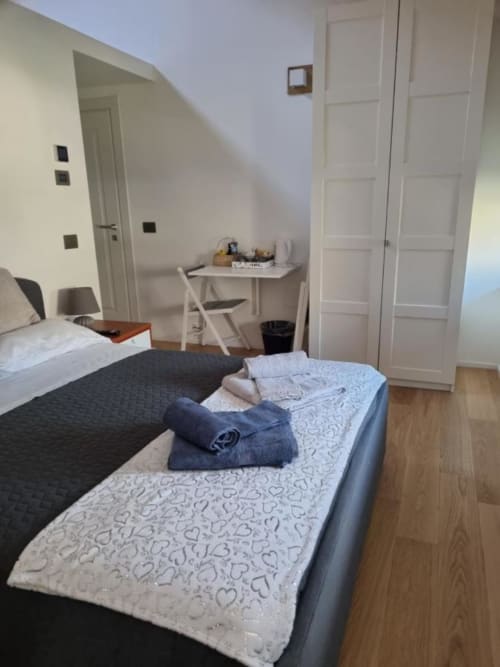 Camera moderna presso il Maso Kreuzberg B&B di Trento con letti gemelli, scrivania e armadio bianco