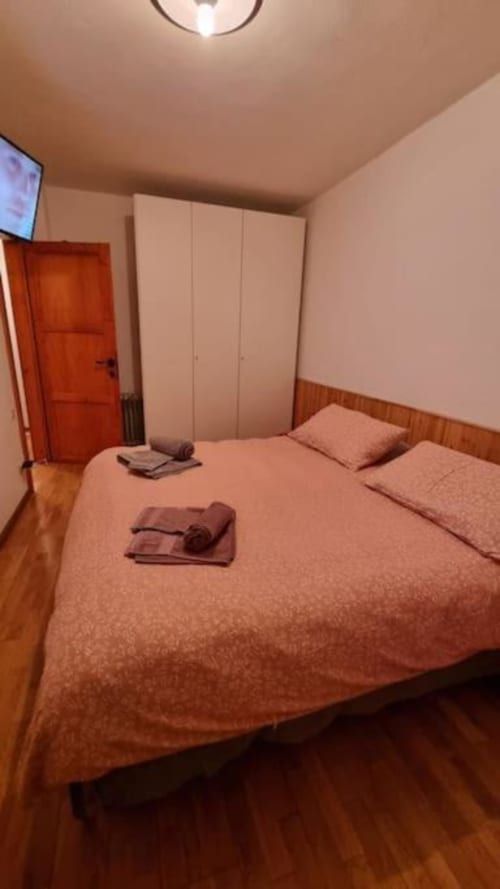 Accogliente camera da letto al Maso Kreuzberg BnB di Trento con letto matrimoniale, armadio e pavimenti in legno