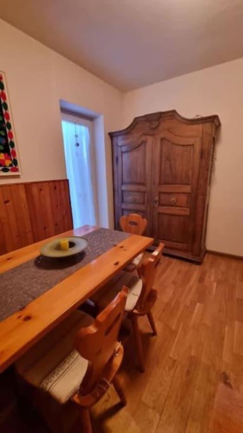 Sala da pranzo rustica presso il B&B Maso Kreuzberg a Trento con tavolo in legno, sedie e armadio tradizionale