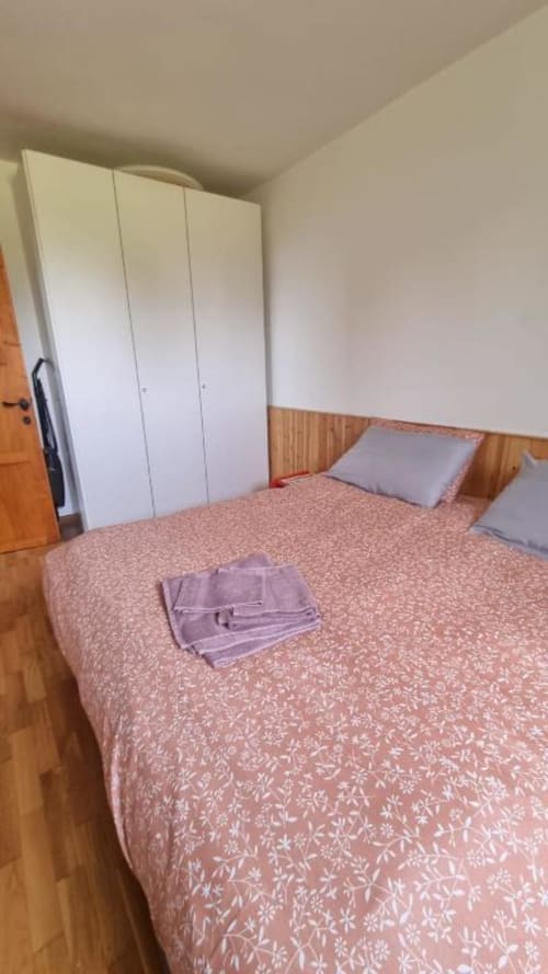 Camera da letto spaziosa dell'appartamento Maso Kreuzberg a Trento con letto matrimoniale, armadio bianco e pavimento in legno