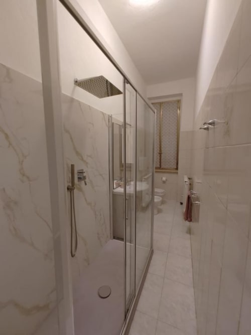 Bagno moderno dell'Apartment Mazzini con doccia in vetro, piastrelle in marmo e finiture contemporanee
