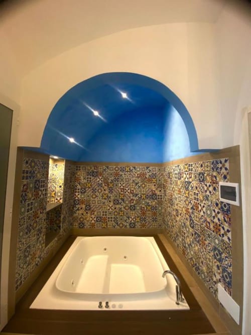 Lussuoso bagno con piastrelle decorative, vasca da immersione e suggestivo soffitto a cupola blu della Suite San Nicola a Sorrento