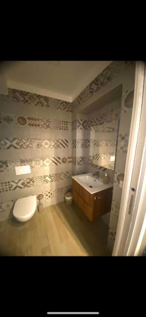 Bagno moderno presso San Nicola Suite Mini Apartments a Sorrento con piastrelle decorate, lavabo e wc