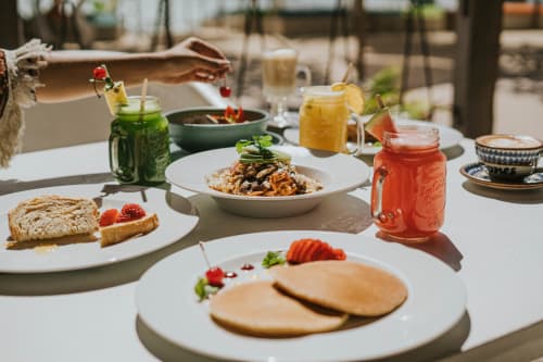 Desayuno al aire libre en 40 Cañones Hotel Mahahual con platos frescos, bebidas coloridas y ambiente tropical