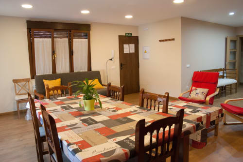 Luminoso comedor compartido en la cabaña Tradición Rural, Nieva, con mesas de madera, cojines coloridos y vistas al jardín