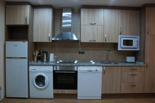Cocina moderna en la casita rural Tradición Rural, Nieva con electrodomésticos de acero inoxidable y encimera de granito