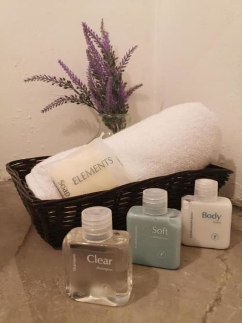 Spa amenities basket at La Familia Hotel featuring purple lavender, towel, and body care products