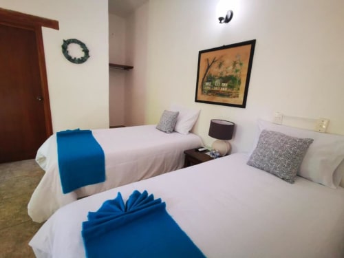 Hotel room at La Familia Hotel with two beds, blue accents, and décor in San Blas, Nayarit
