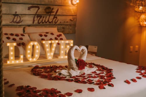 Habitación romántica con luces LOVE, toallas de cisne y pétalos de rosa en el Hotel 40 Cañones de Mahahual