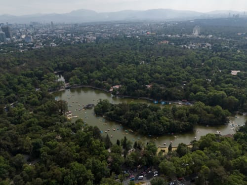 Vista aérea de lagos y bosques de Ciudad de México con el horizonte urbano y montañas de fondo cerca del hotel Casa Donceles