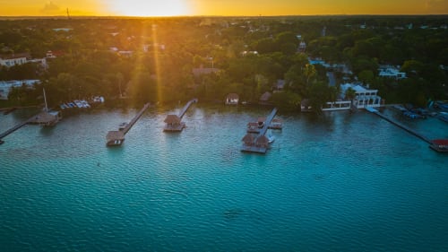 Hotel 40 Cañones a orillas del mar en Mahahual con muelles de madera al atardecer frente a las aguas turquesas del Caribe
