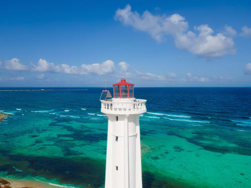 Faro rojo y blanco con vista a las aguas turquesas del Caribe en Mahahual, México