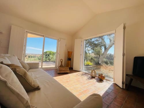 Quarto luminoso com portas de terraço abertas para vistas do jardim na villa Corvatos Casas do Monte, Almodôvar