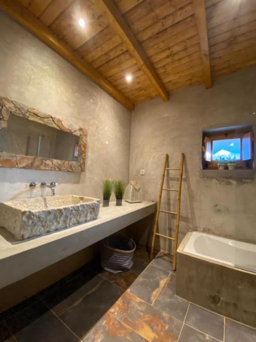 Modern bathroom at Corvatos Casas do Monte villa with stone sink, wooden ceiling beams, bathtub, and mountain view window