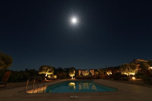 Piscina iluminada à noite em Corvatos Casas do Monte, Almodôvar. Grounds luminosos, céu estrelado e piscina tranquila.