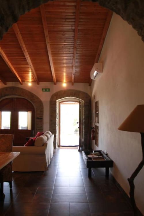 Modern villa interior at Corvatos Casas do Monte with wooden ceiling, archway entrance, tile flooring and furnished living