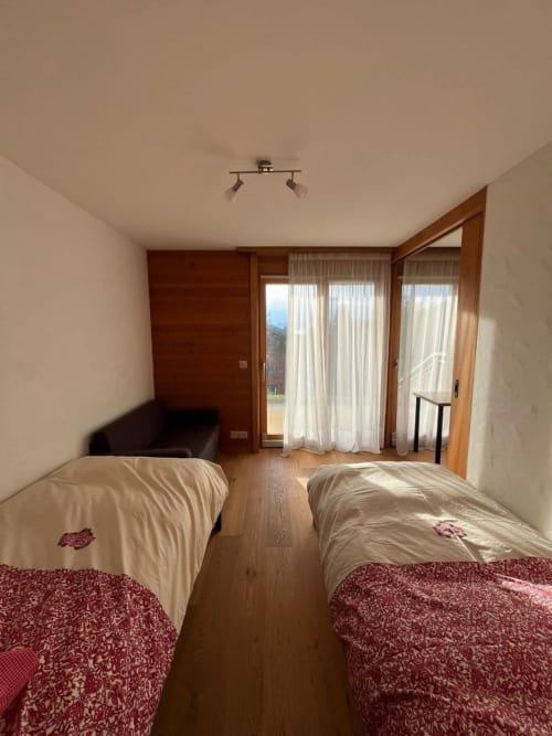 Chambre twin avec vue sur les montagnes à l'appartement Grangette Villars, Villars-sur-Ollon, sol en bois et accès à la terrasse