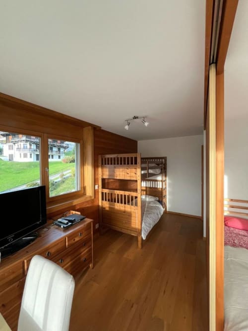 Chambre en bois avec lits superposés, TV et vue sur les montagnes à l'appartement Grangette, Villars-sur-Ollon