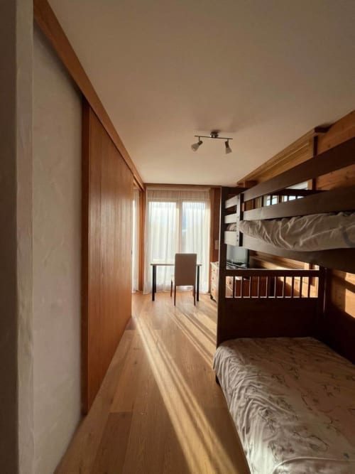 Spacieuse chambre avec lits superposés, mobilier en bois et vue sur les montagnes à l'appartement Grangette Villars à Villars-sur-Ollon